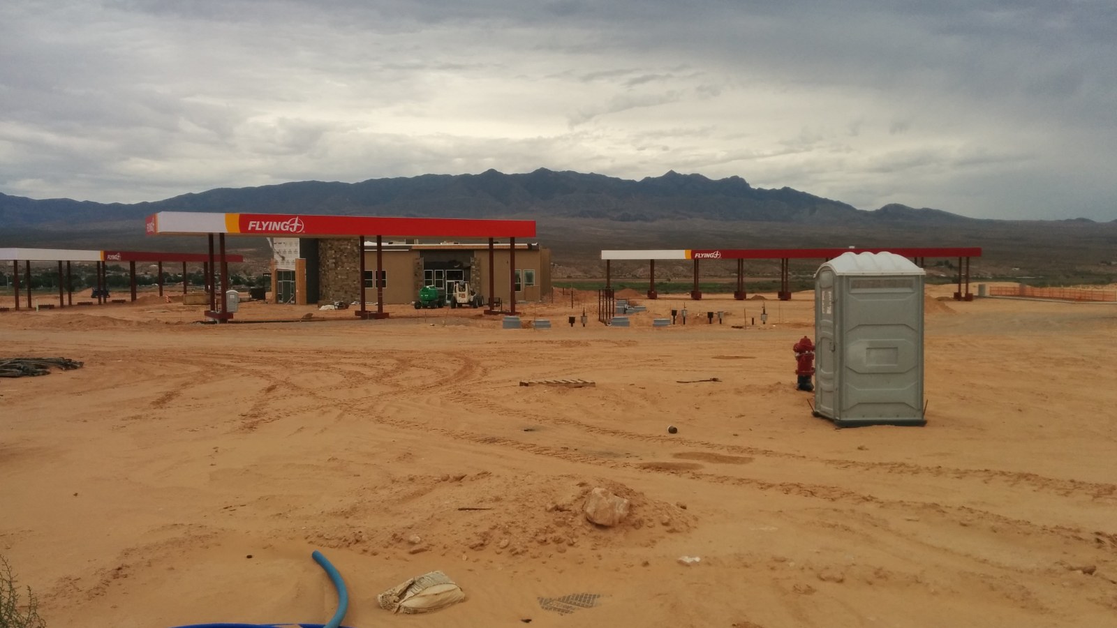 Early-stage petrol station construction with canopy structure and unpaved forecourt