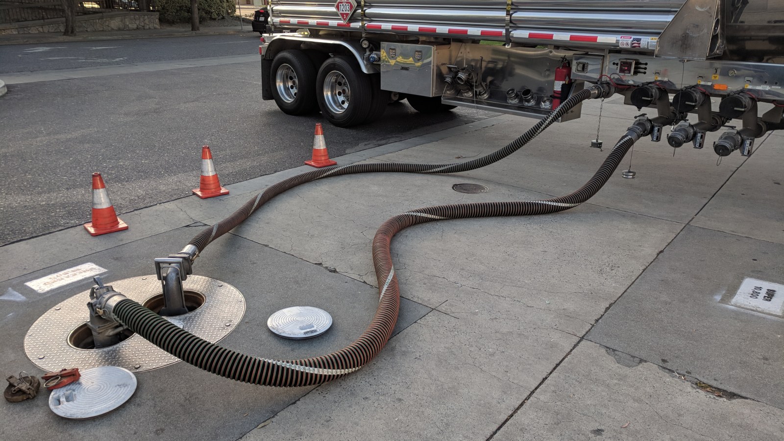 Fuel delivery hoses connected to underground tank fill points at an operating station